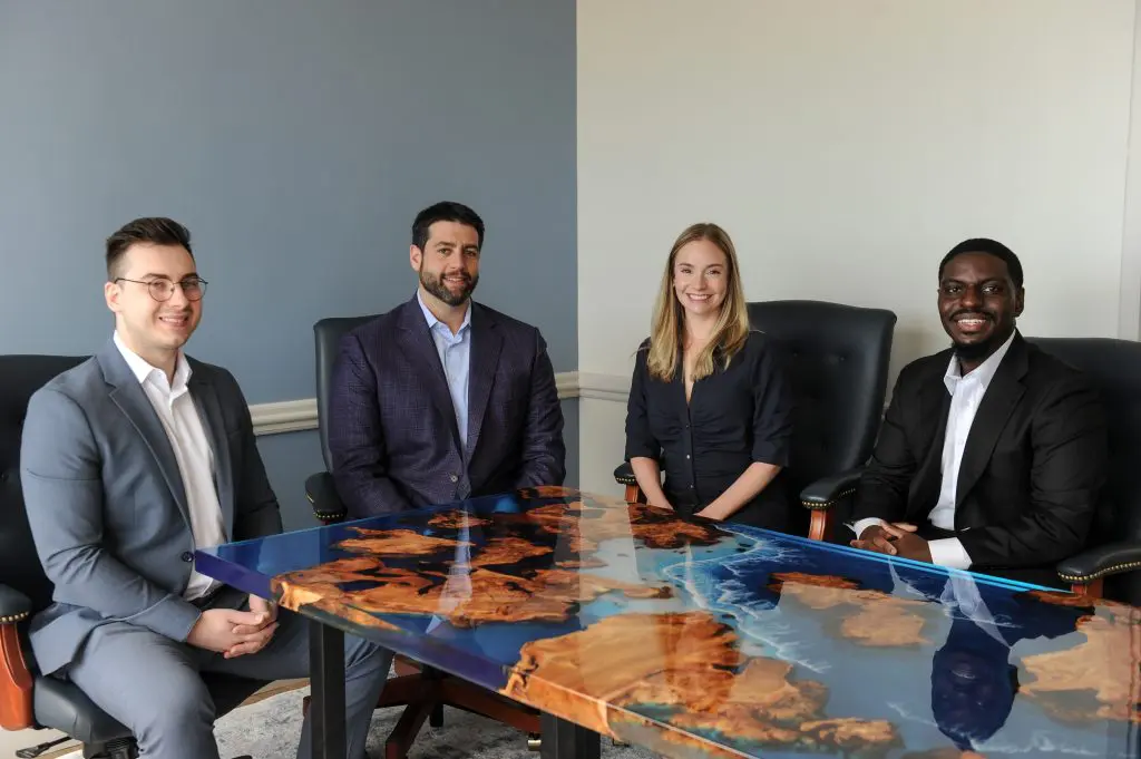Fuchs Financial advisors having a team meeting. Alex Cal on the left, Ben Fuchs and Gina Mazzadra in the middle, and Eddy Agyeman on the right.