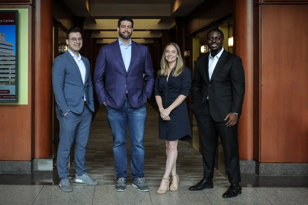 Fuchs Financial retirement planners taking a team photo. Alex Cal on the left, Ben Fuchs and Gina Mazzadra in the middle, and Eddy Agyeman on the right.