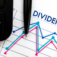 paper and pen with the words dividends on the paper